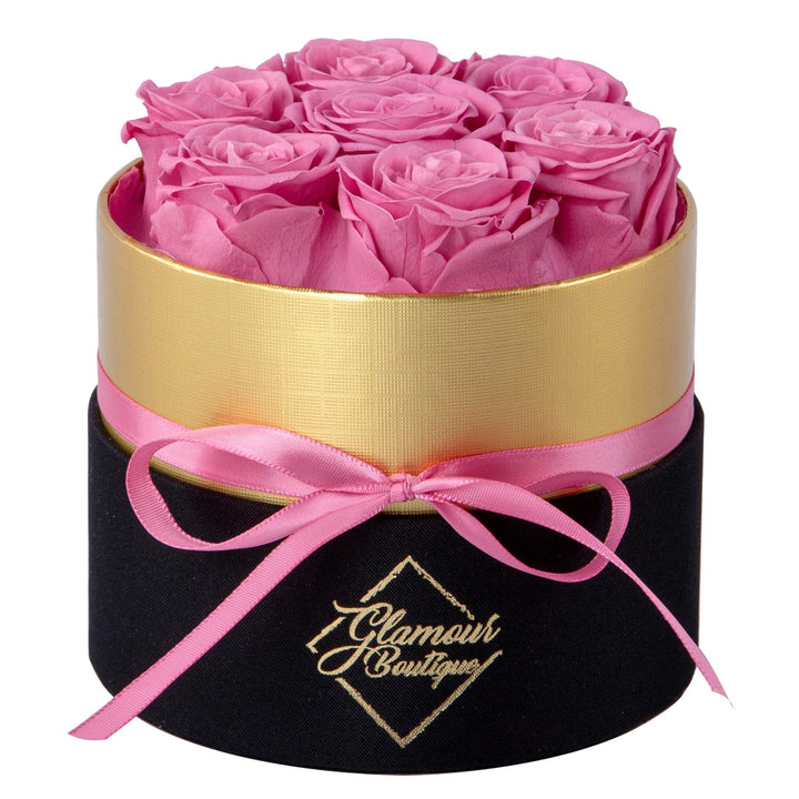 Lasting Beauty round black gold box with 7 pink preserved roses by Glamour Boutique